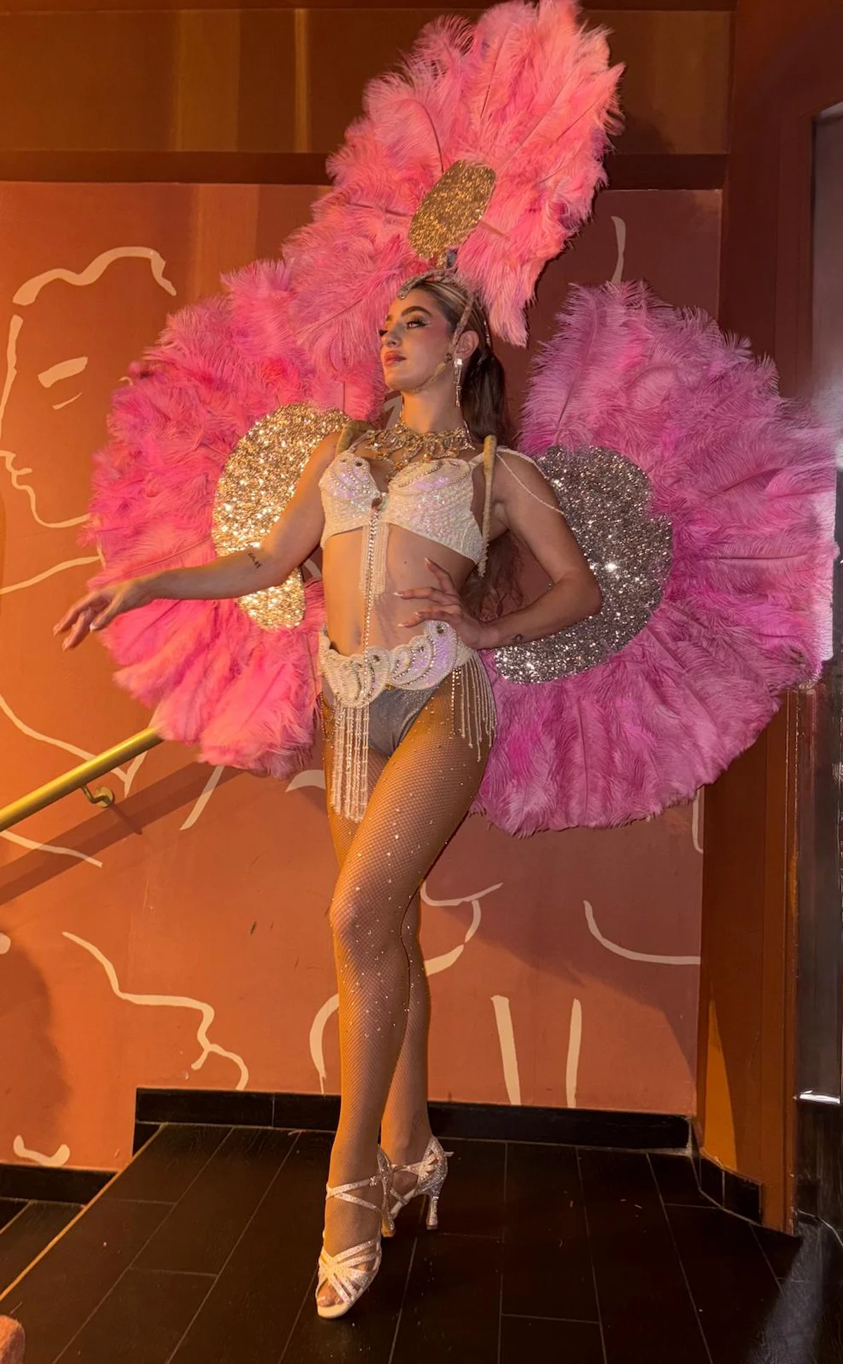 Artiste en costume à plumes roses lors d’une performance sur la Côte d’Azur.